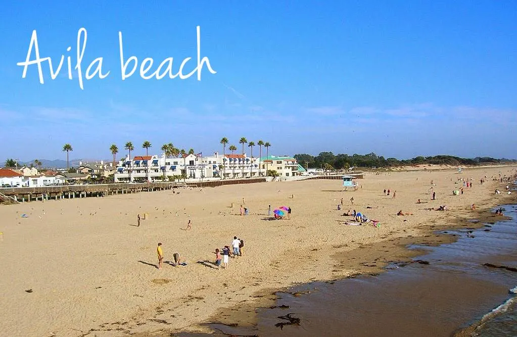 A wide beach area with golden sand and people in it