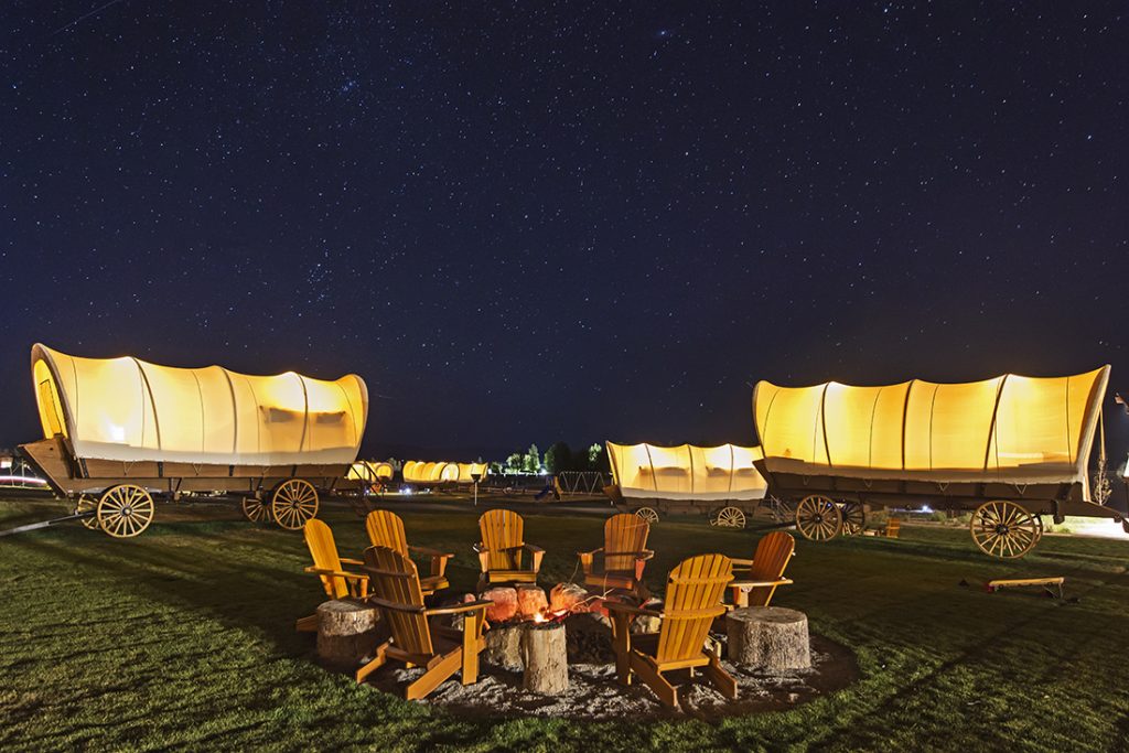 chairs around a firepit and glamping wagons