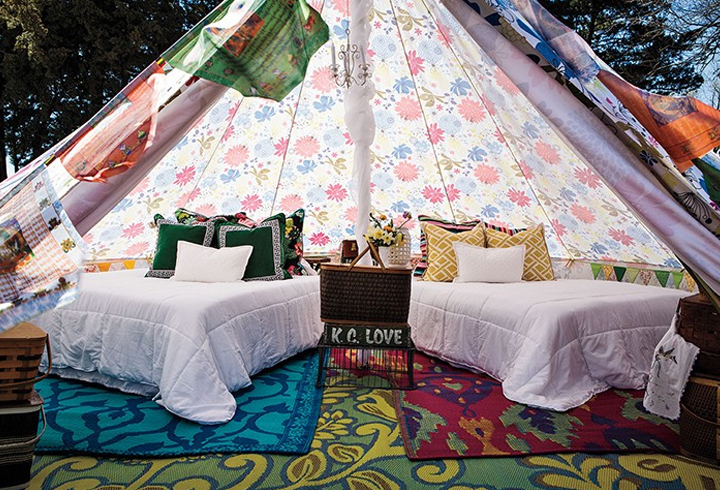 the interior of a glamping tent with two beds and a bedside table