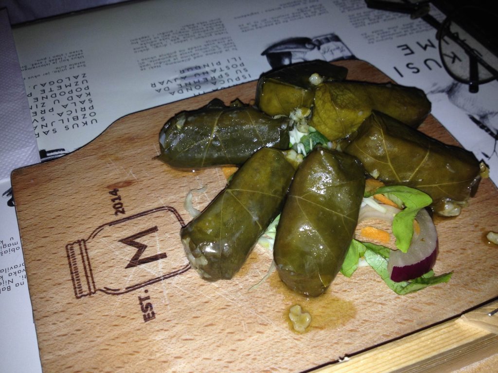 a meal of filled vine leaves on a wooden board