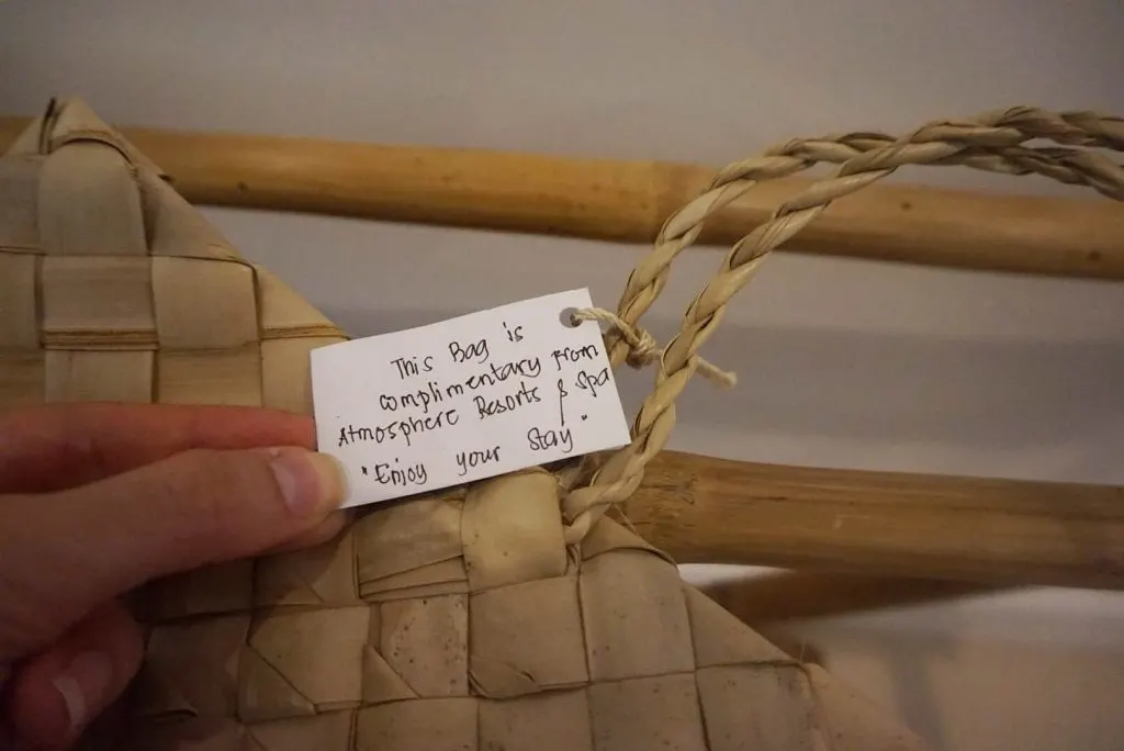 A woman's hand holding a note attached to a tote bag