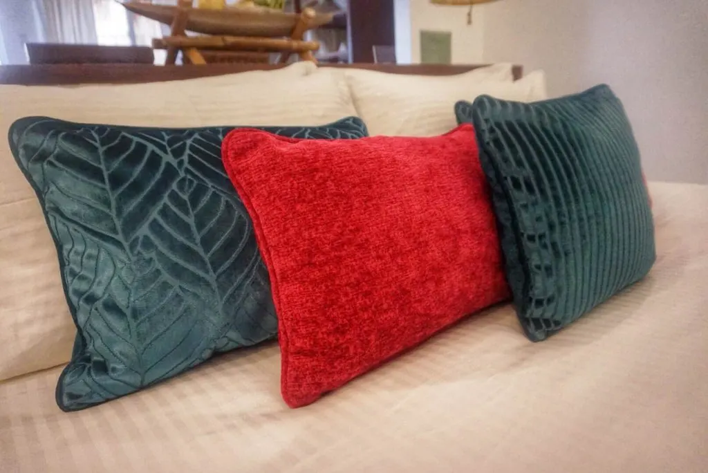 close up image of three cushions, two of which are blue and the one in the middle red