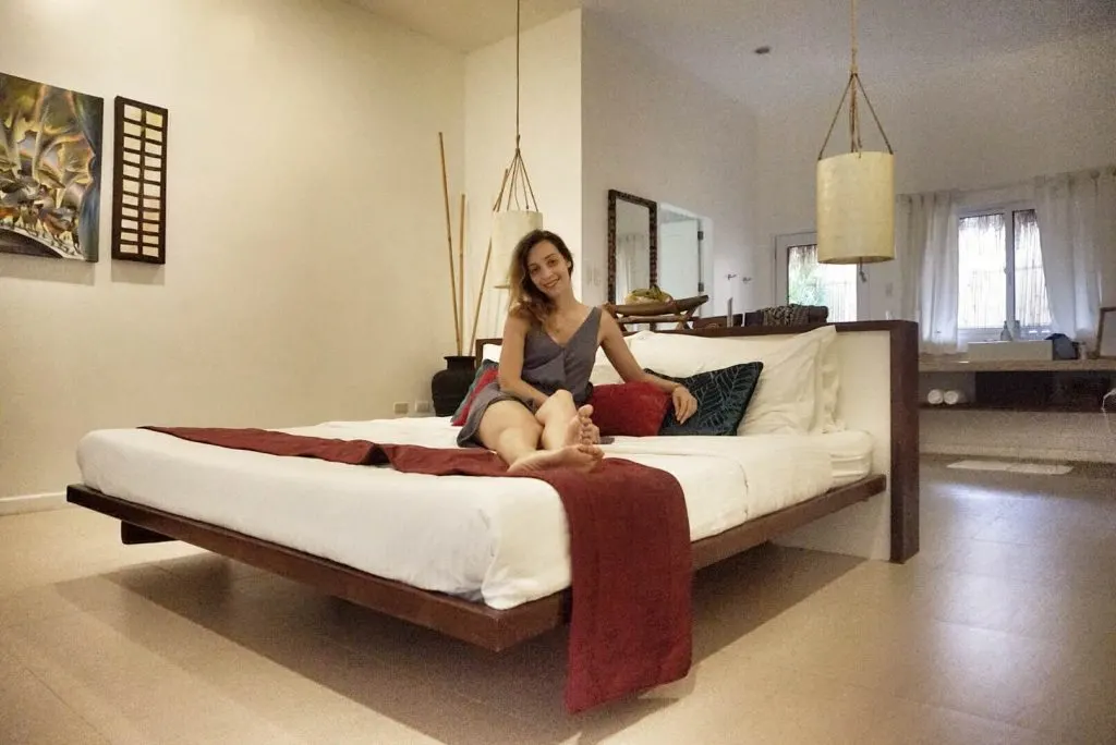 A woman lying on a bed in a spacious hotel room