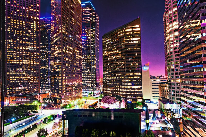 the city of Los Angeles at night, with tall skyscrapers lit up