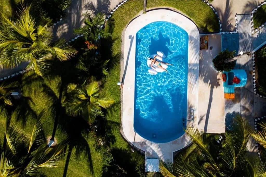 Overhead image of a woman relaxing in a pool with a floatie at a Puerto Holbox hotel. 