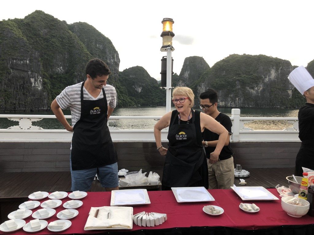 A man and a woman standing in front of a long table with aprons