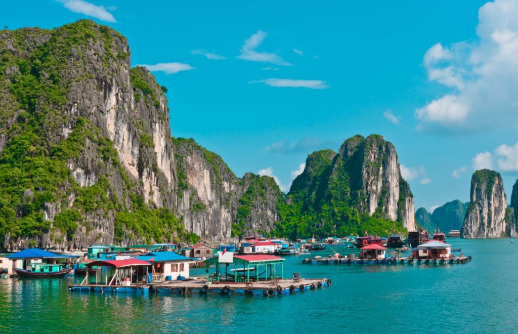 Halong Bay on a sunny day, with massive karsts in the background 