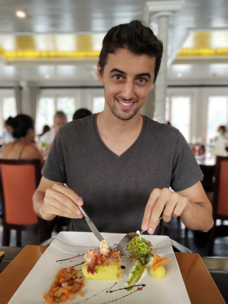 A man cutting food on a plate in a restaurant