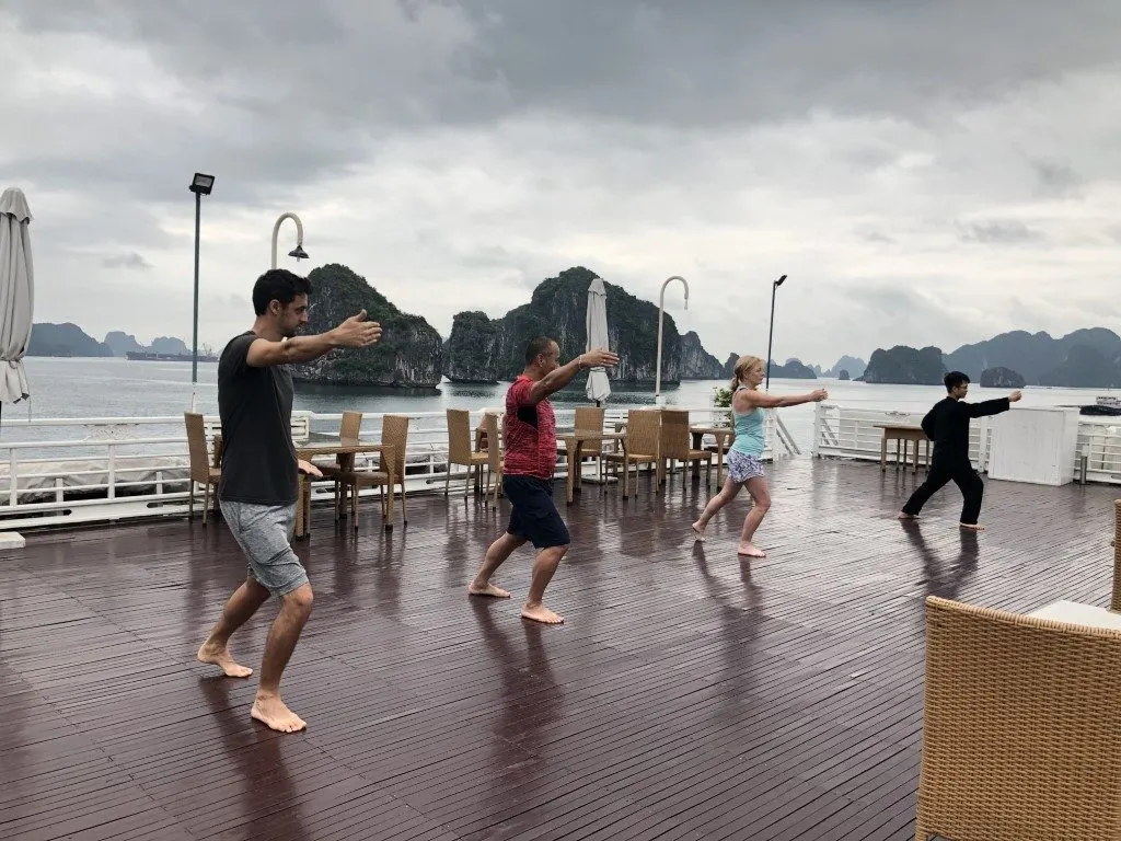 People practicing tai chi on the deck of a boat