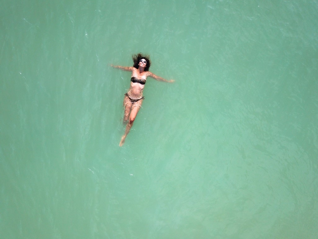 A drone image of a woman swimming in the sea in Cozumel, Mexico