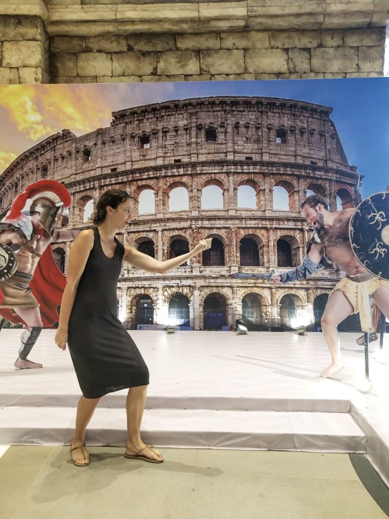 A woman posing in front of a poster of the Colosseum