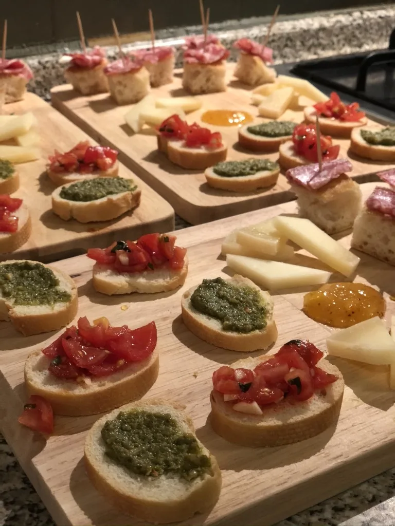 Italian Bruschetta, cheese, and jam placed on three wooden boards during a cooking class