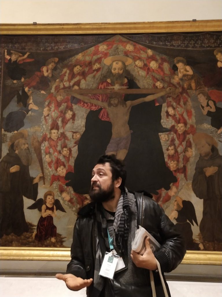 A tour guide explaining a painting in Galleria dell'Accademia 