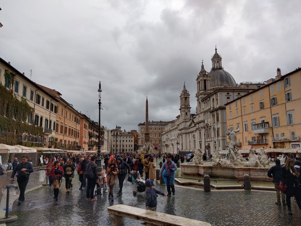 Piazza Navona seen on a rainy day, with people walking in all directions