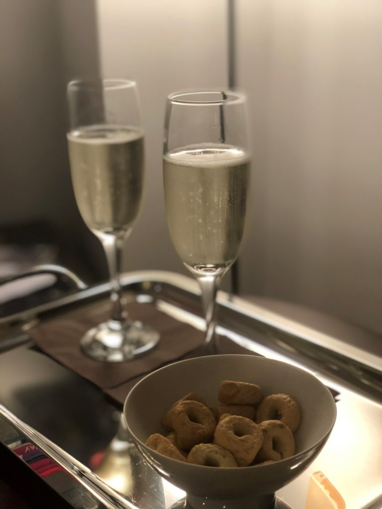 Two glasses of champagne and a bowl with snacks, inserted in a post about Rome itinerary 