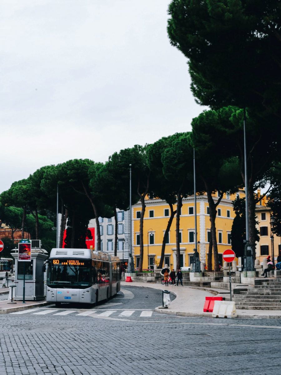 A Roman cobblestone street with a grey bus, inserted in a post about 3 days in Rome itinerary 