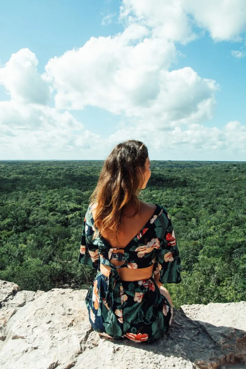 Woman sitting at the top of the pyramid at the Coba Ruins.