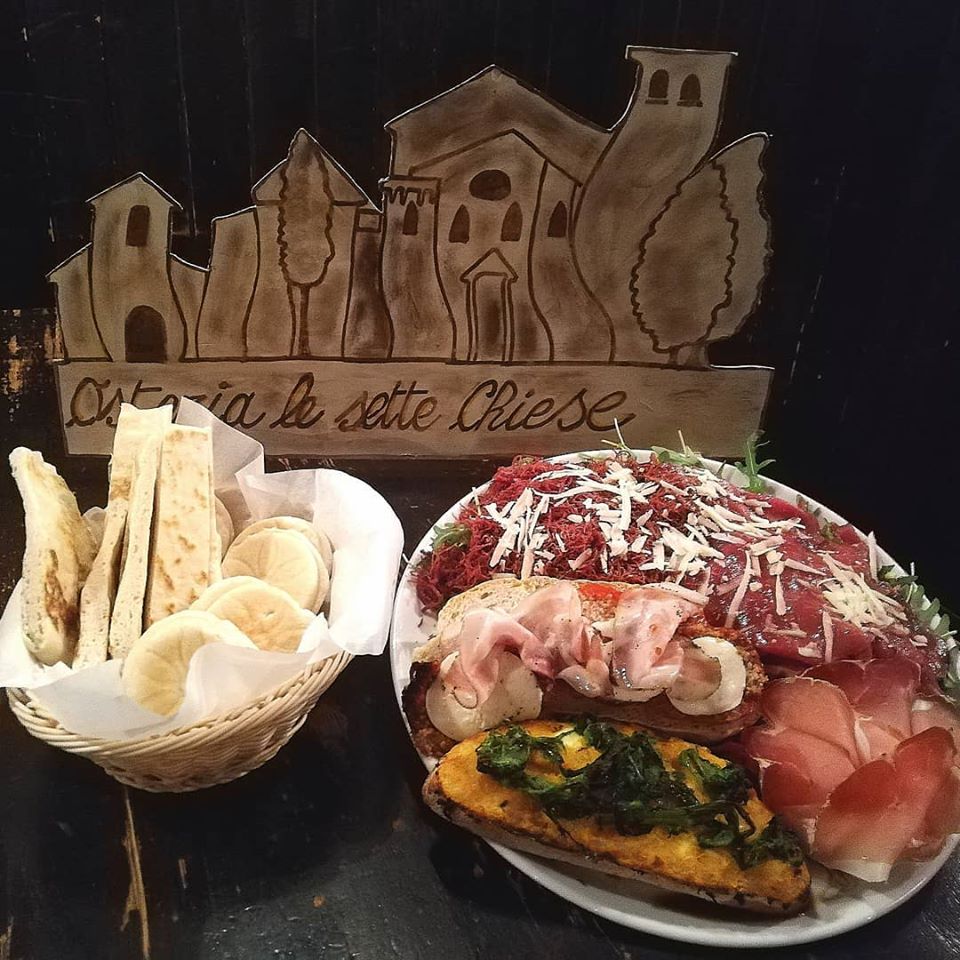 A basket with bread, and a plate with bruschetta, inserted in a post about Bologna Restaurants 