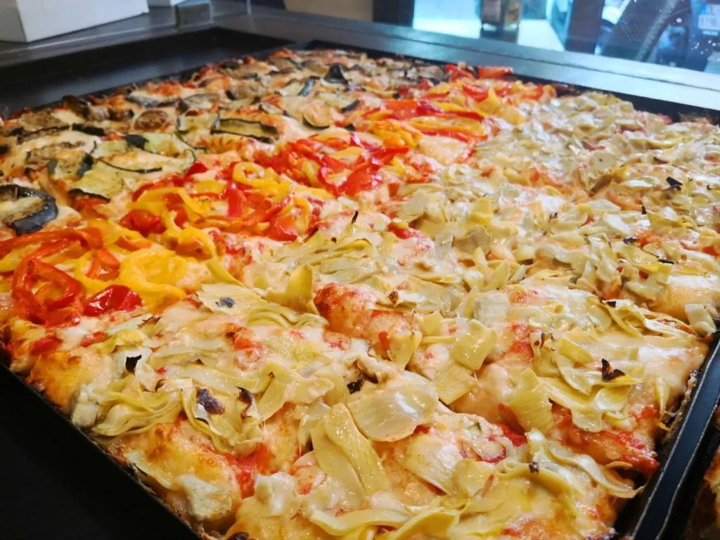 Pizza slices on display, inserted in a post about Bologna restaurants