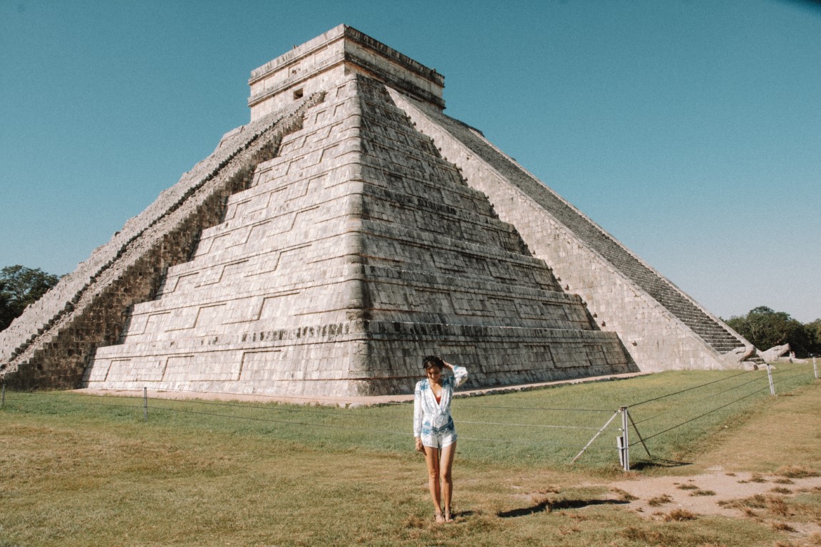 A woman standing in front of Kukulcan Pyramid 