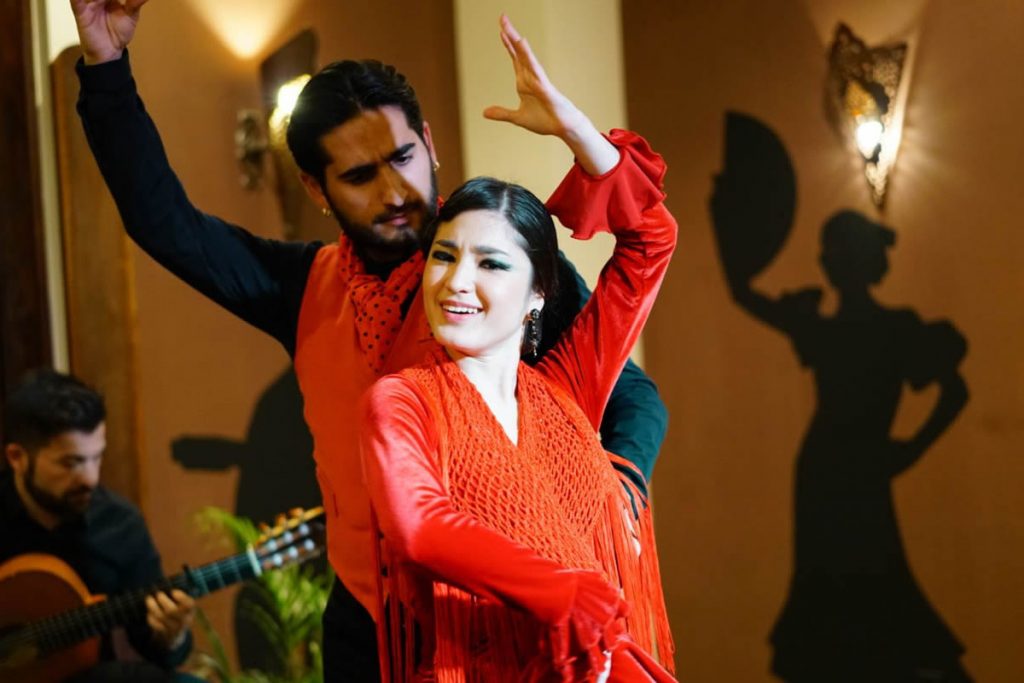 A couple of flamenco dancers performing on stage 