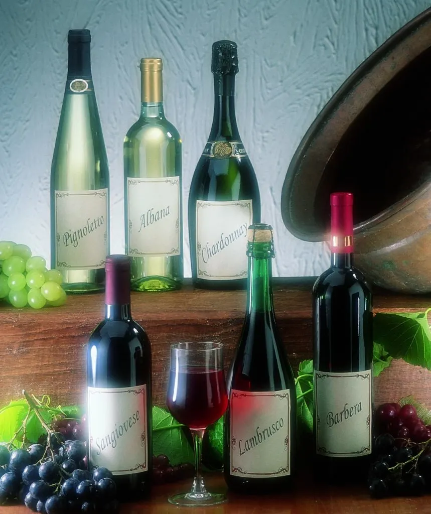 An image of six bottled of wine, and a glass of red wine 