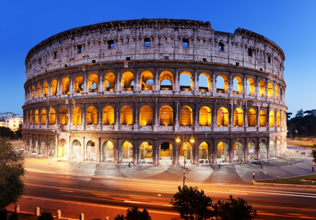 The Colosseum in Rome, lit up and set against an evening sky 