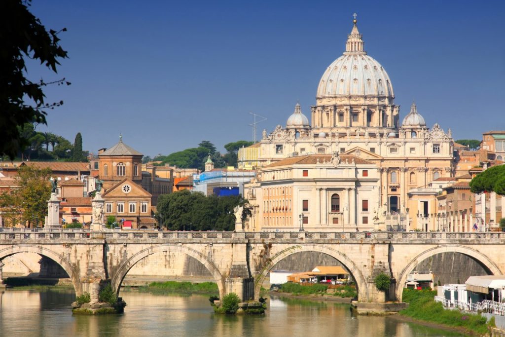 Image of the river Tiber with a bridge crossing it, and in the background the St Peter's Dome