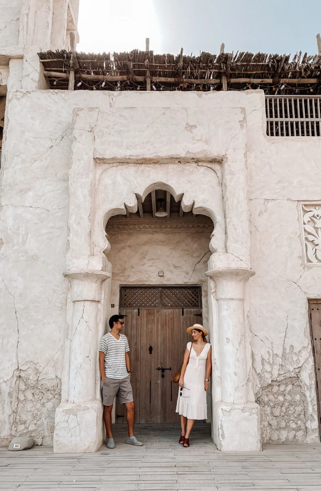 Couple standing in front of a door in the Al Seef district in Dubai.