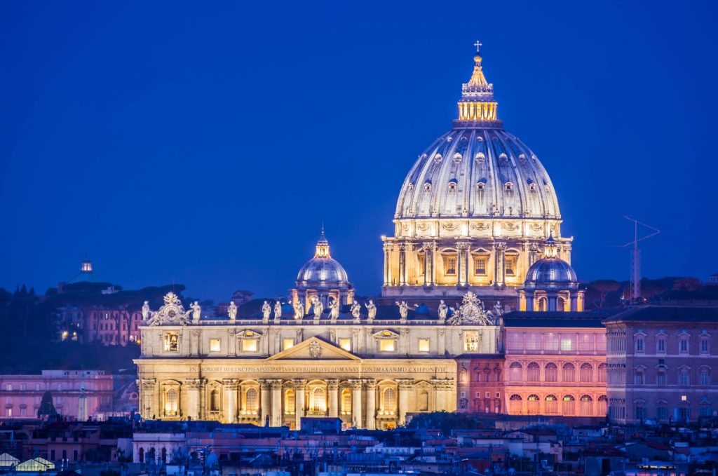 St Peter's Basilica completely lit up, set against the night's sky. Inserted in a post about a day trip from Florence to Rome 