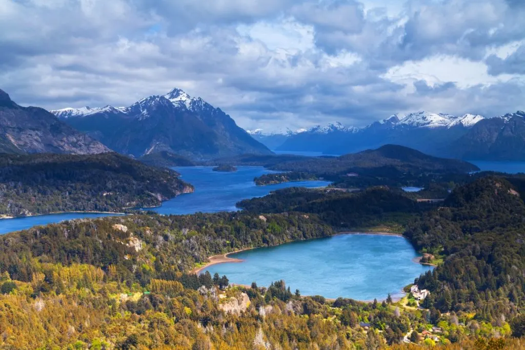 A viewpoint image of two lakes surrounded by forest, and mountains in the background