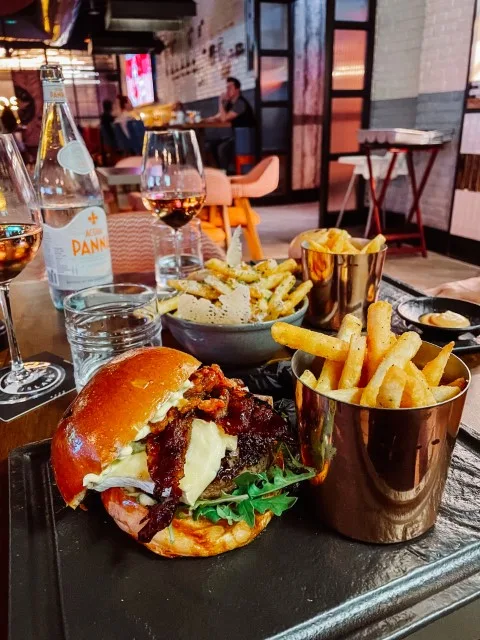 A burger and a bucket of fries on a  table