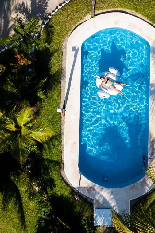 A woman floating in a swimming pool as she relaxes in a floatie