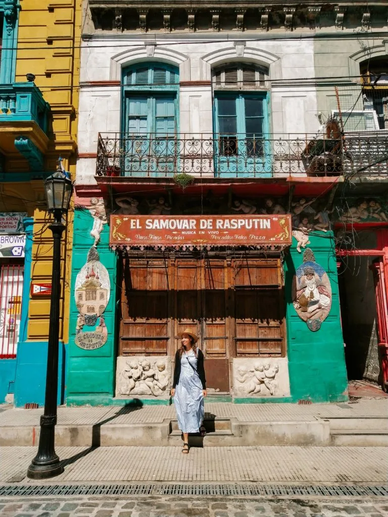 A woman standing outside a colorful building in Buenos Aires