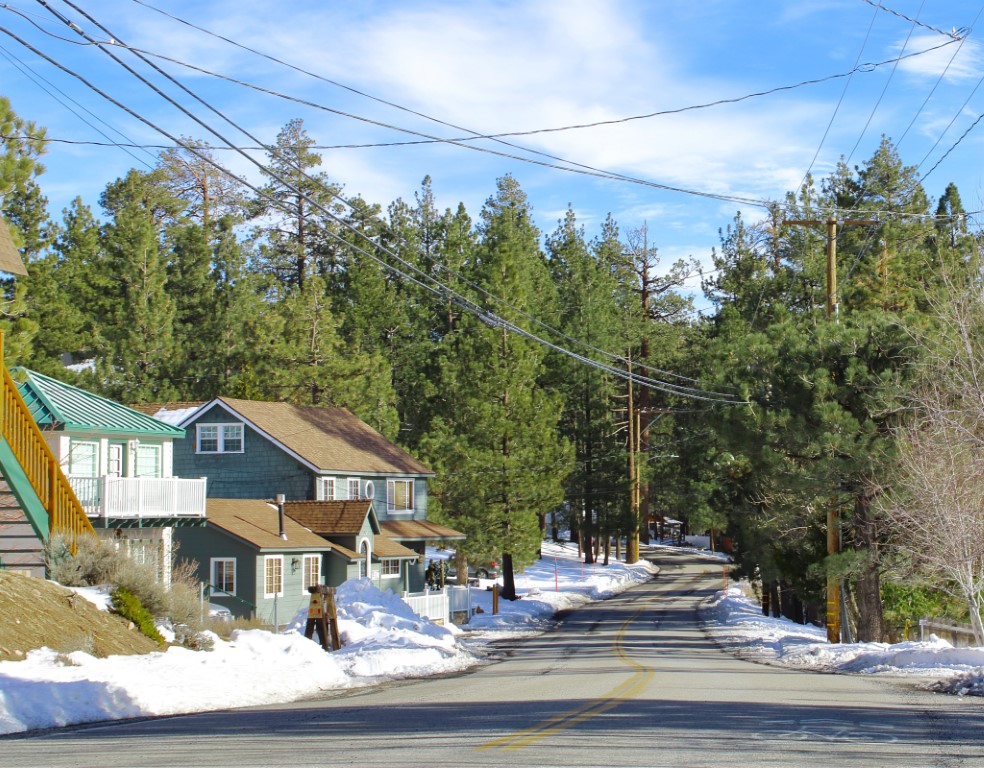 A road with snow on both sides and trees