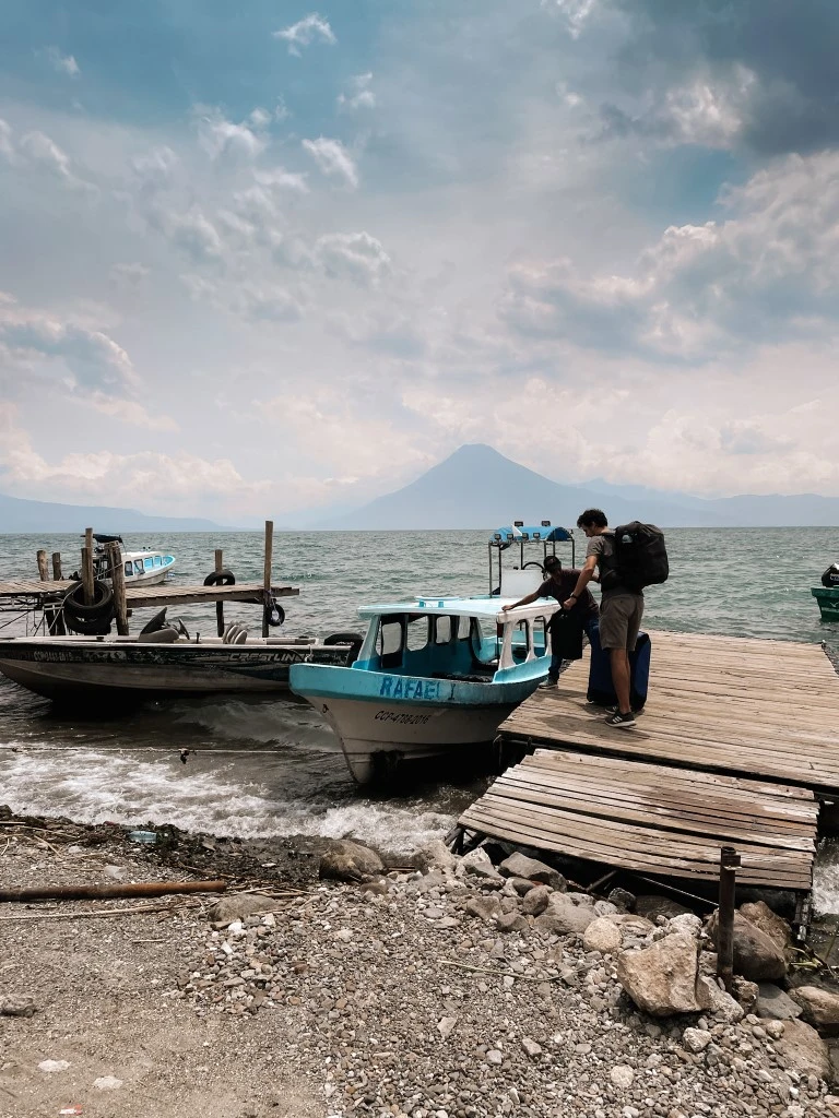 A man loading luggage into a boat taxi in Lake Atitlan