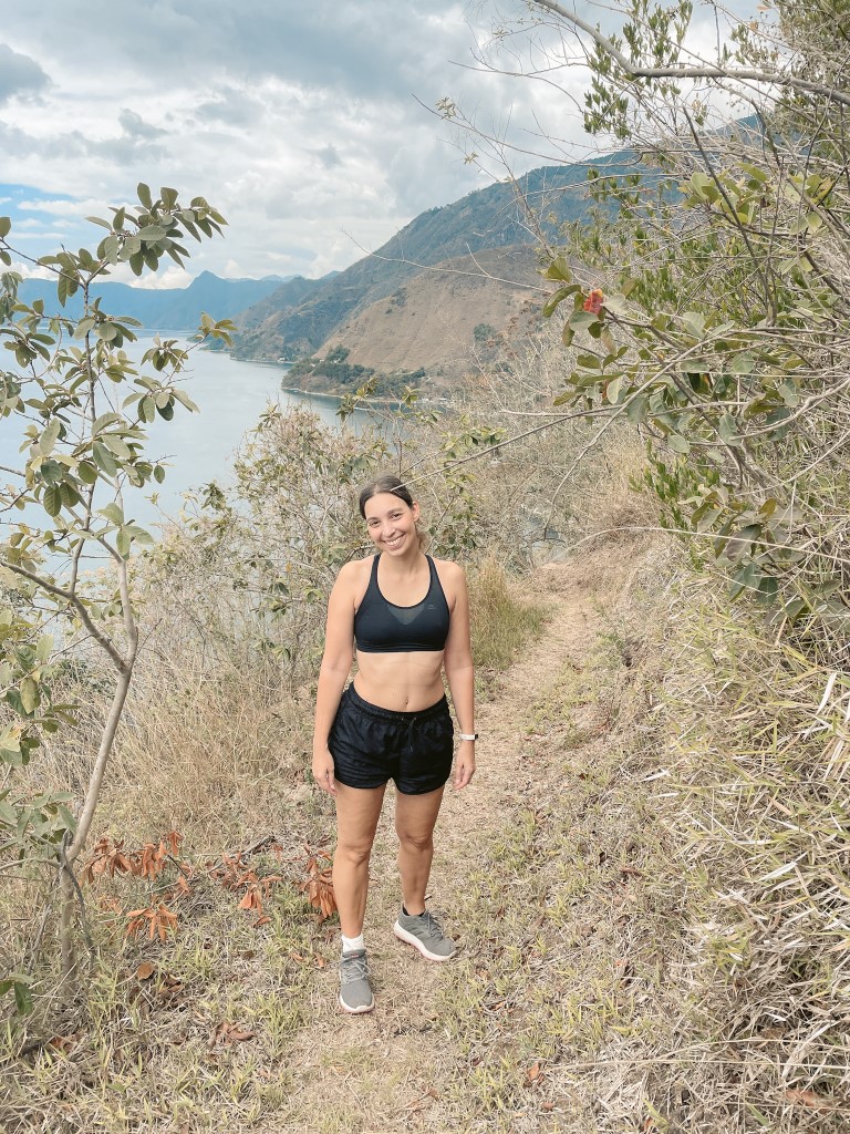 A woman wearing black shorts and a sports bra, hiking in Lake Atitlan 