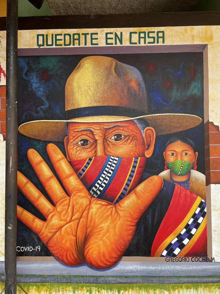 A mural that shows two Guatemalan people wearing face masks