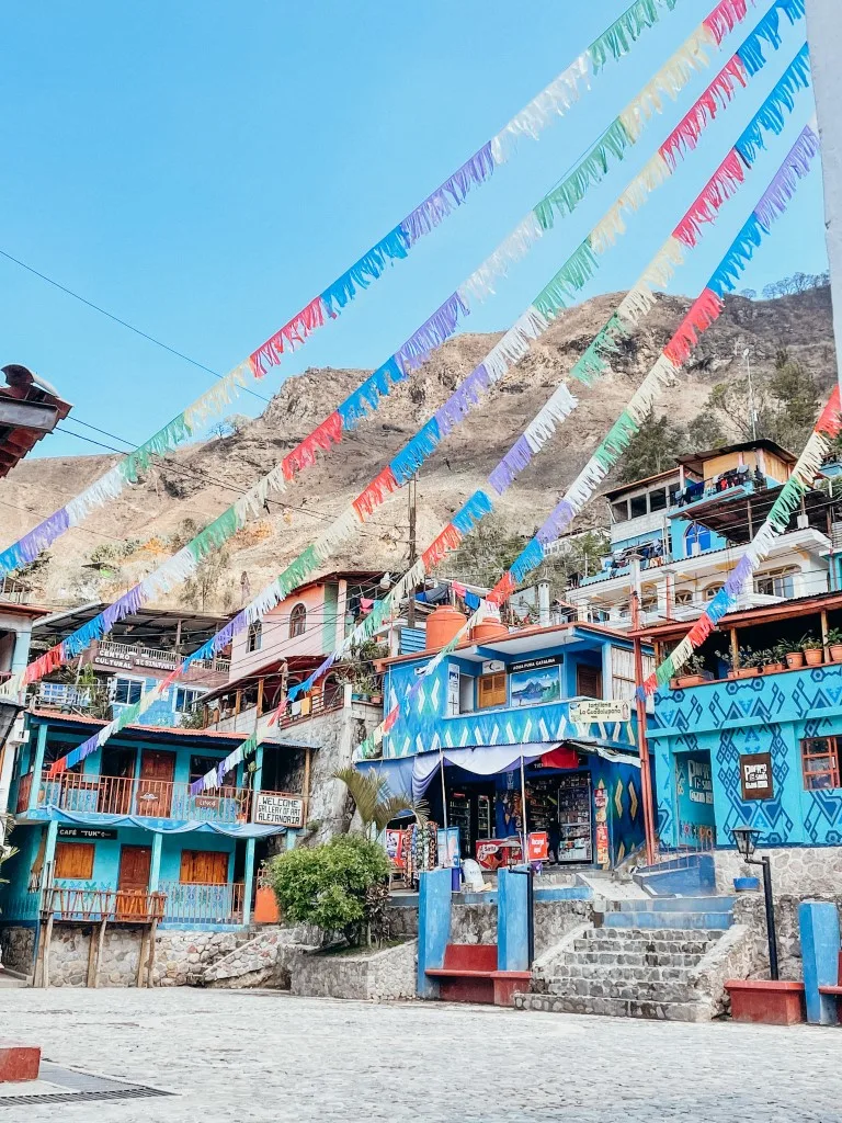 Blue houses surrounding a square, and colorful decorations