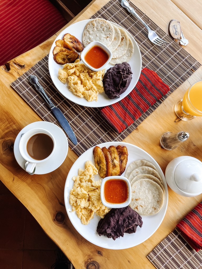 Overhead shot of two breakfast plates, and a cup of coffee