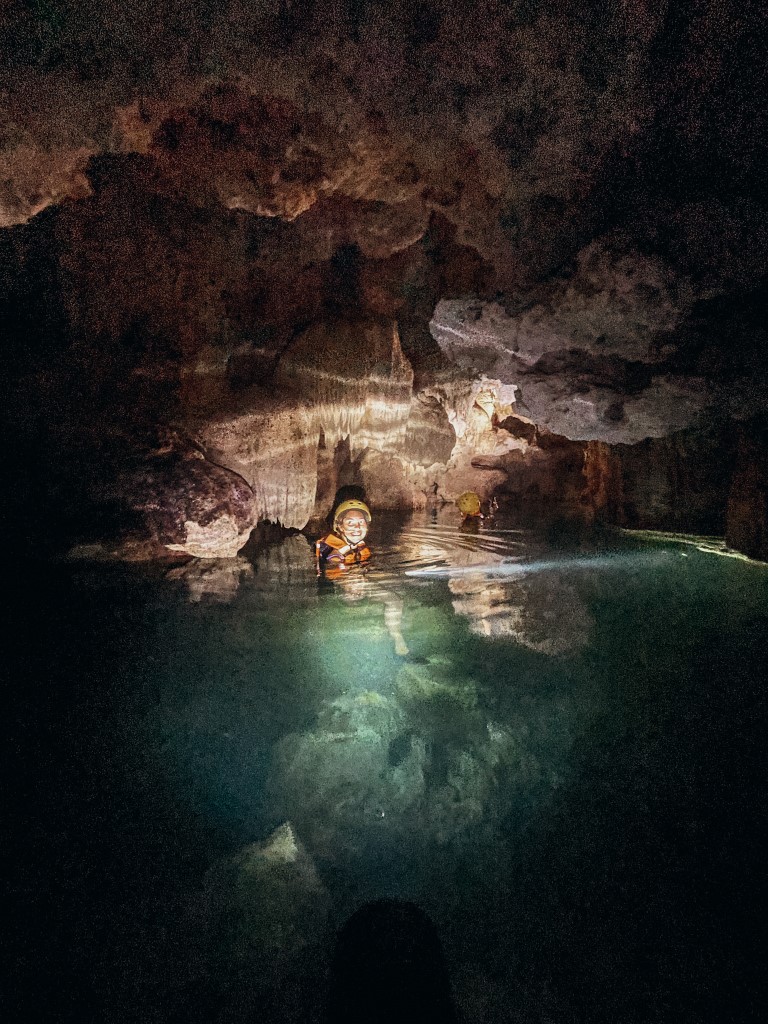 Image of a girl smiling in an underground river at Rio Secreto, one of the best excursions from Playa del Carmen