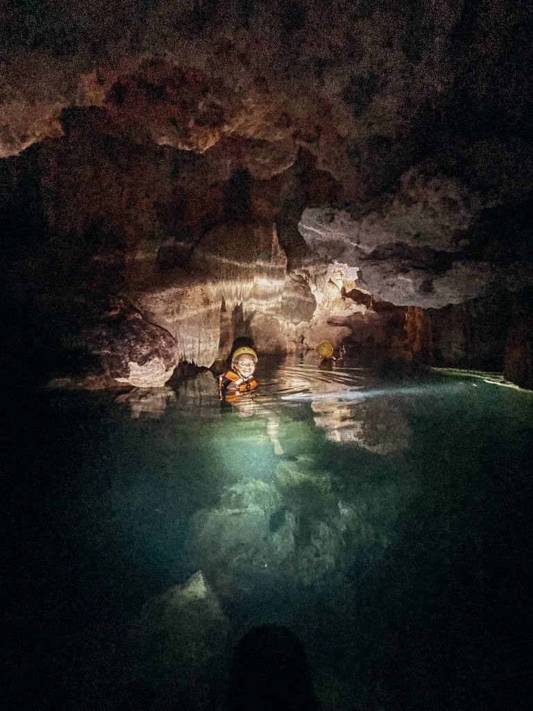 A woman swimming in an underground river