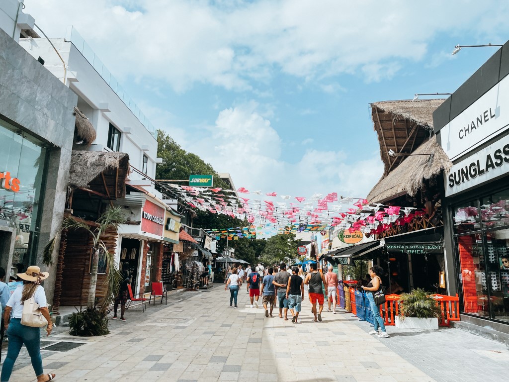 Quinta Avenida in Playa del Carmen, with colorful flags and shops on both sides