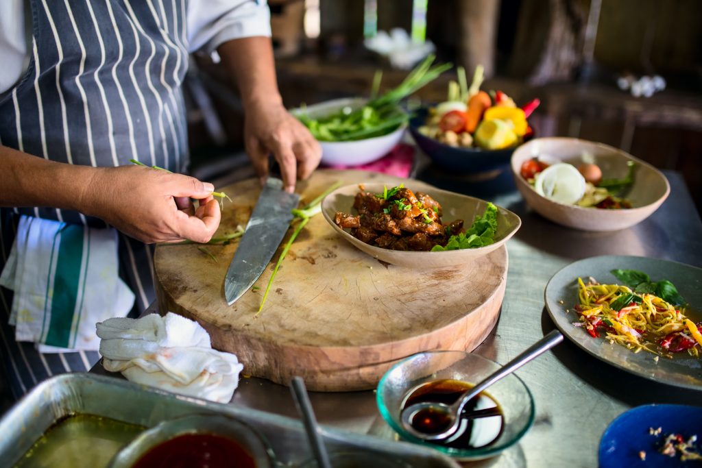 The hands of a chef preparing various dishes