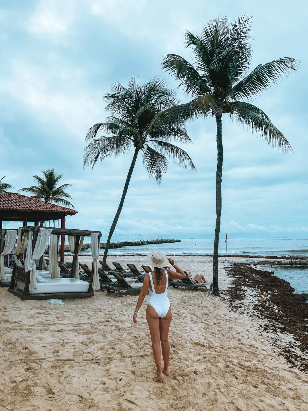 A woman wearing a white swimsuit in a beach 