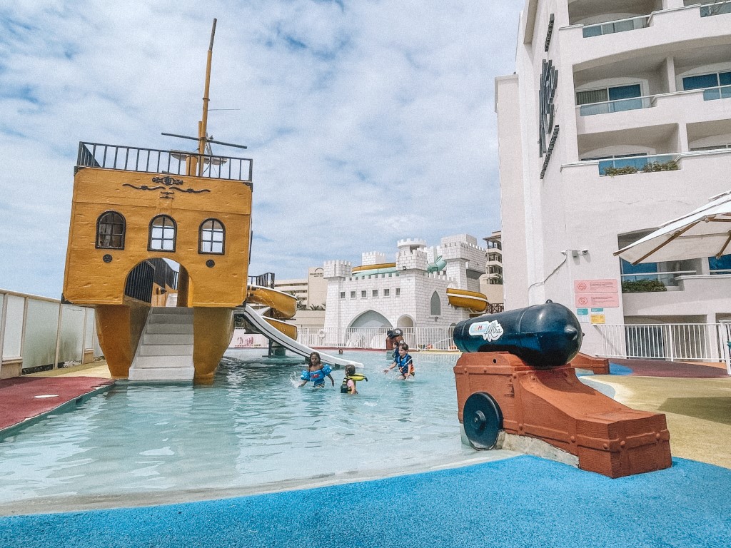 A children's water park with small kids splashing in the pool