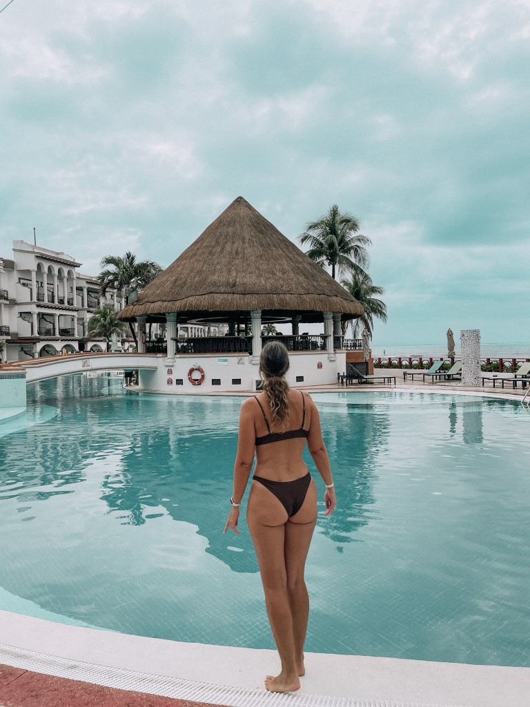 A woman standing on the edge of a pool 