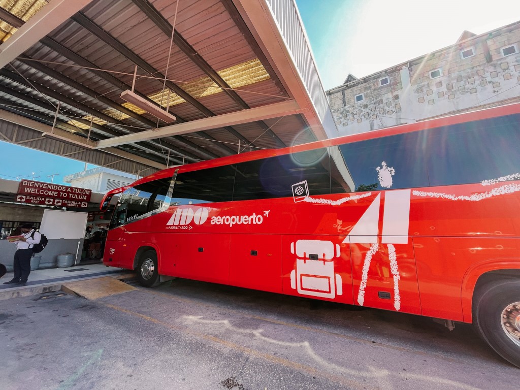 Image of a red ADO Bus parked in a bus station in Mexico