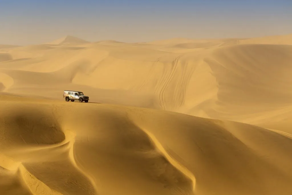 A 4WD vehicle on the sand dunes of a desert