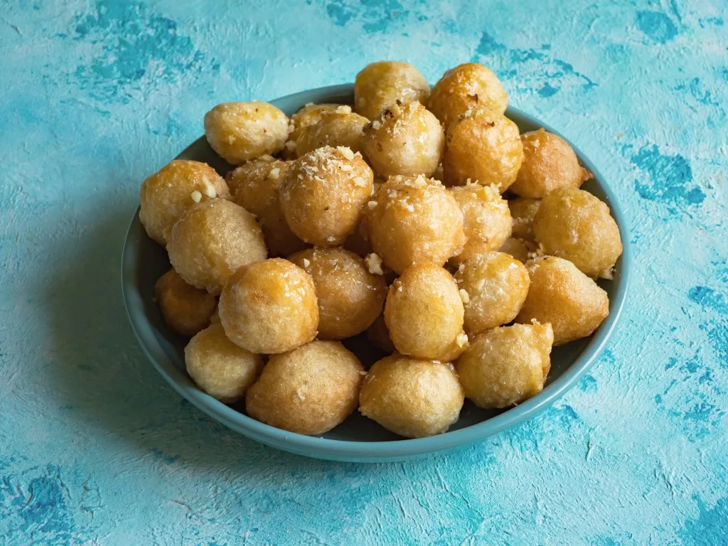 A blue bowl with Luqaimat sweets